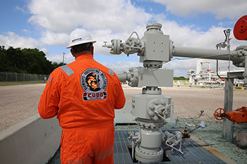 A well control engineer inspecting a wellhead